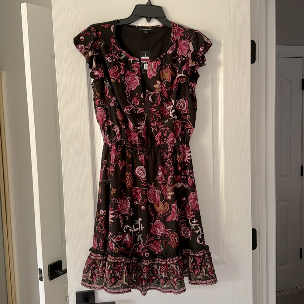 Flouncy dress with floral print on black background.